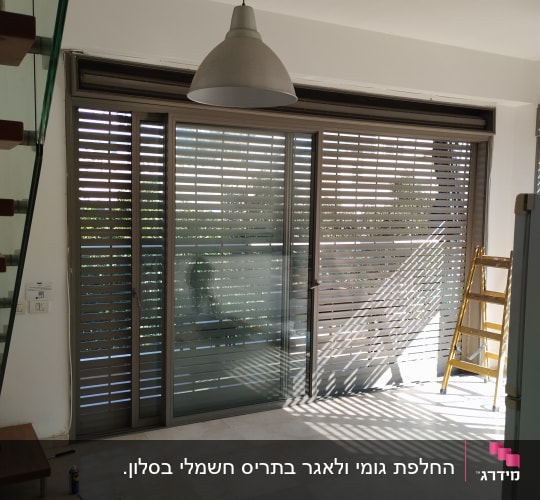 תריסים חיצוניים אפורים על חלון זכוכית גדול